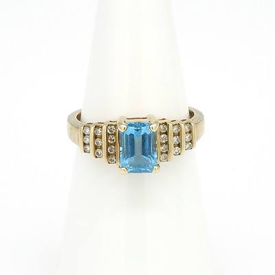 9ct Yellow Gold Ring with Emerald Cut Blue Topaz and Twenty Round Brilliant Cut Diamonds