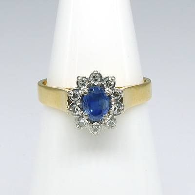 18ct Yellow and White Gold Ring, Oval Cluster with Centre Medium Blue Ceylonese Type Sapphire and Ten Single Cut Diamonds in Claw Setting