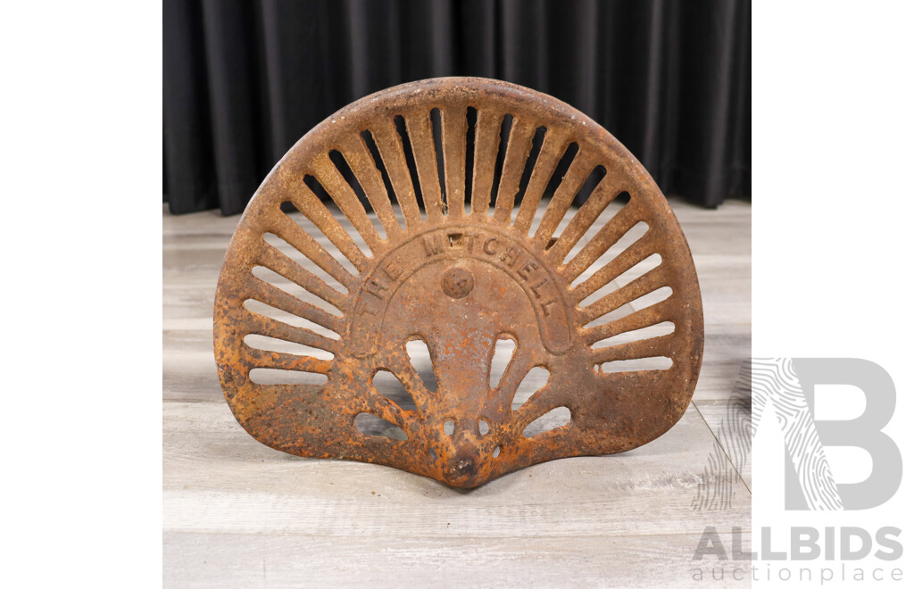 Two Antique Tractor Seats Including The Mitchell Cast Iron and Pressed Steel Example