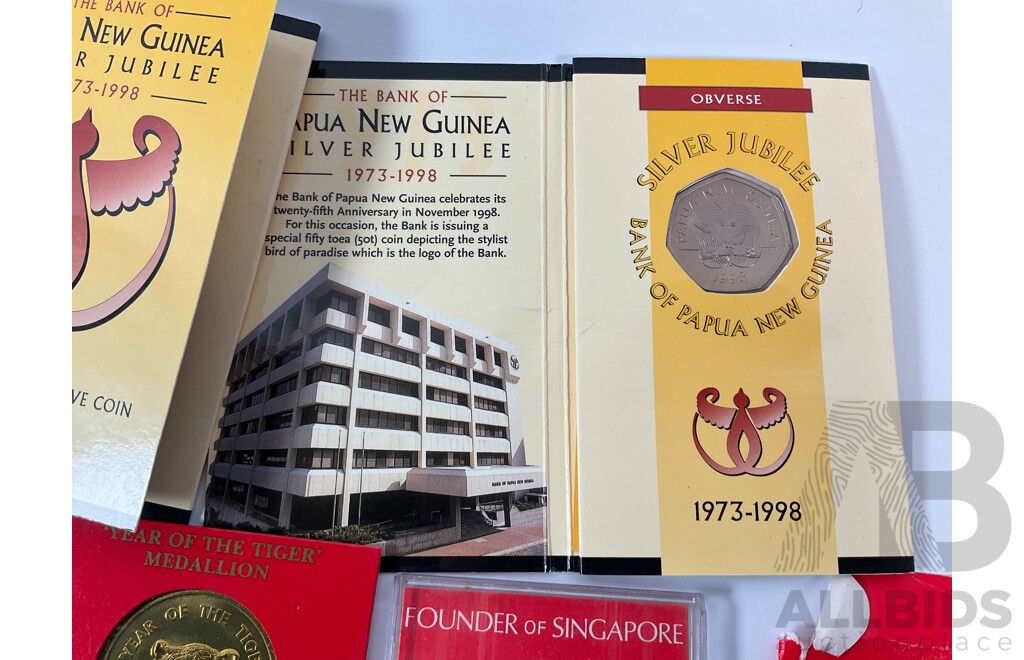 Collection of Vintage International Carded Coins, Chinese Confucius Medallion Two Singapore Sir Thomas Raffles Medallions, Two Papua New Guinea 1998 Fifty Toea Coins, Bank of PNG Silver Jubilee