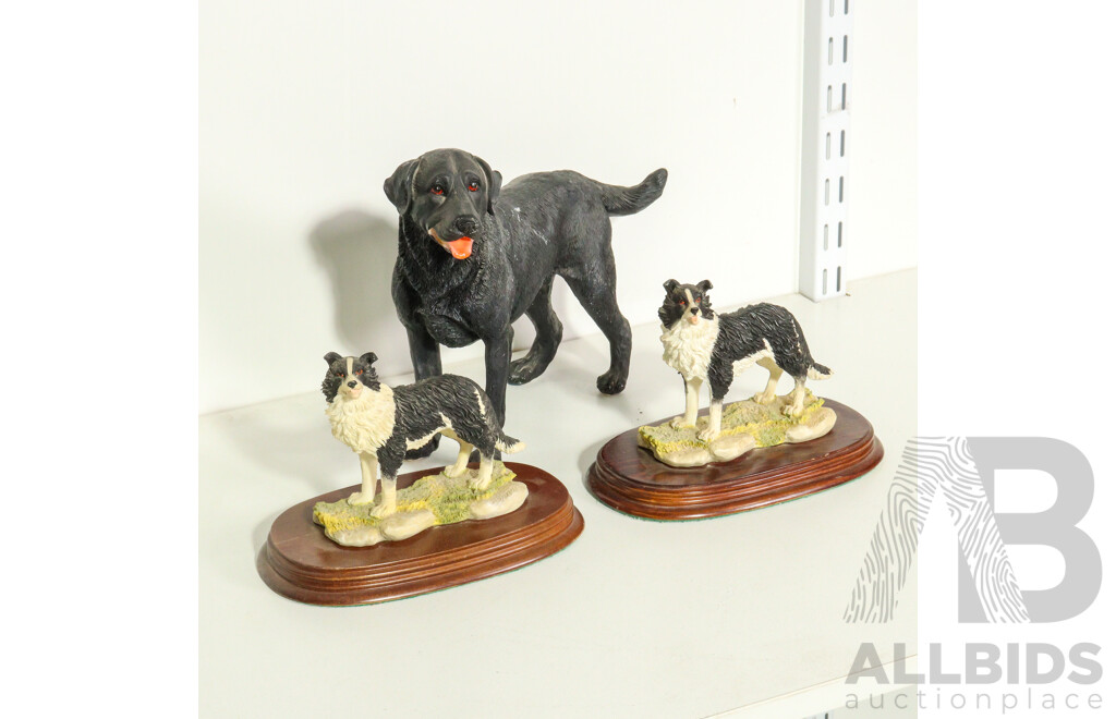 Three Resin Dog Figurines: Border Collies on Wooden Bases and a Labrador