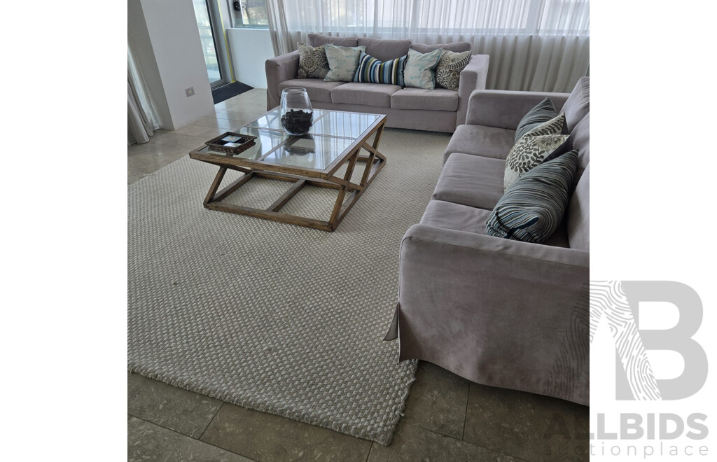 Entire Lounge Room Setting Including 2 X Three Seater Beige Microfibre Lounges, All Cushions, Rib Weave Natural Wool Rug and Designer Cross Base Glass Coffee Table